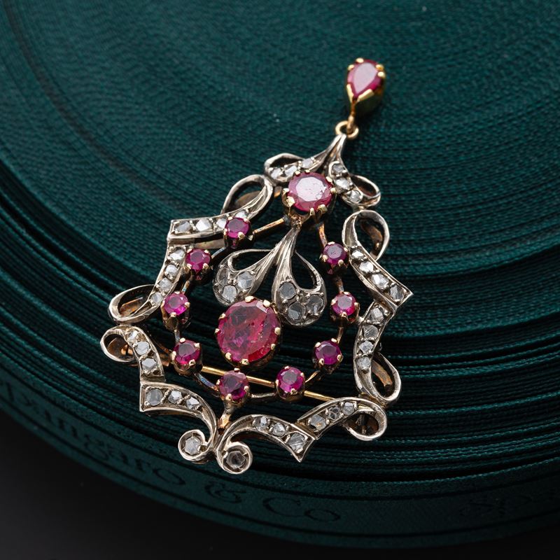 CIONDOLO/SPILLA IN ORO BIANCO 18 KT CON RUBINI E DIAMANTI A ROSETTA RAPPRESENTANTE MOTIVO FLOREAL...