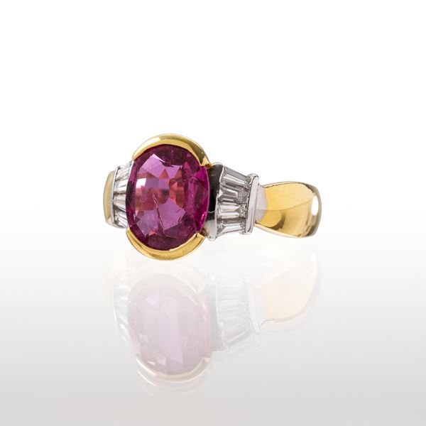 ANELLO IN ORO GIALLO 18 KT E ORO BIANCO 18KT CON RUBINO OVALE CHIARO CON OTTIMA TRASPARENZA NON CERTIFICAT PER CT. 3.25 E DIAMANTI TAGLIO TAPER CT. 0.48 DI BUONA QUALITA’ MISURA IT 15-E 51